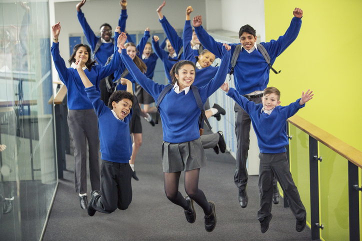 Enthusiastic students leaping in the school corridor